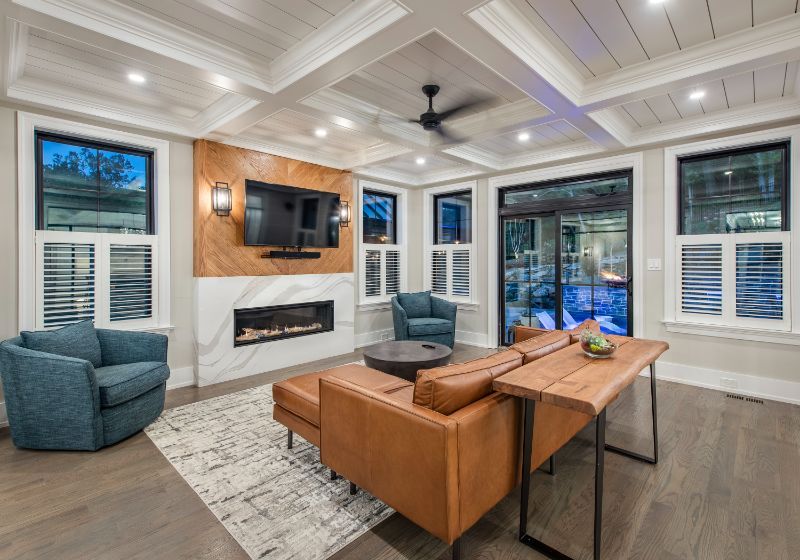 custom living room with large windows, a ceiling fan, beautiful hardwood floors
